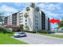Beautiful condo building featuring tropical landscaping, covered parking, and ocean views at 2045 Gulf Of Mexico Dr # M1-514, Longboat Key, FL 34228