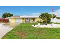Inviting single-story home featuring a well-manicured lawn and solar panels at 212 66Th Avenue W Dr, Bradenton, FL 34207