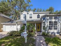 Charming two-story home features a welcoming yellow door, lush landscaping, and classic architectural details at 2306 63Rd W St # 40, Bradenton, FL 34209