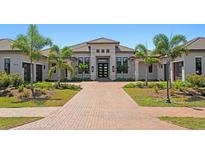 Beautiful single-story home featuring a tiled roof, symmetrical landscaping, and an inviting front entryway at 3212 Signet Ct, Sarasota, FL 34240