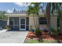 Back exterior view showcasing a screened patio and tropical landscaping for a relaxed outdoor living at 3411 15Th E St, Ellenton, FL 34222