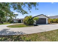 Charming single-story home featuring a circular driveway and an attached two-car garage at 3810 Hidden River Rd, Sarasota, FL 34240