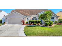 Charming one-story home with a well-manicured lawn, mature landscaping, and a two-car garage at 4585 Dover Street E Cir, Bradenton, FL 34203