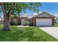 Charming single-story brick home featuring a well-manicured lawn and mature shade tree with a swing at 613 E 49Th E St, Bradenton, FL 34208