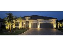 Beautifully illuminated home featuring a stone facade, tile roof, and two-car garage at 7327 Summerland Cv, Bradenton, FL 34202