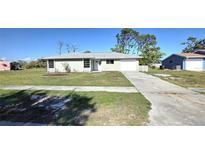 Charming single-story home with a well-manicured lawn and a concrete driveway at 7524 Kavanda St, North Port, FL 34287