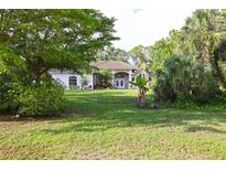 Charming home featuring a well-manicured lawn and lush, mature landscaping at 950 Trotter St, Nokomis, FL 34275