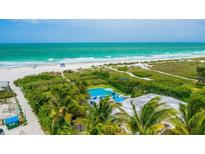 Breathtaking aerial view showcases a waterfront property with a pool and lush tropical surroundings at 102 77Th St, Holmes Beach, FL 34217
