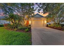 Charming home featuring a two-car garage, landscaped yard, and a warm, inviting exterior at 12175 Maple Ridge Dr, Parrish, FL 34219