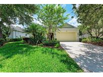 Charming single-story home featuring a well-manicured lawn and a two-car garage at 12175 Maple Ridge Dr, Parrish, FL 34219