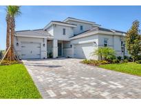 Beautiful two-story home featuring a three-car garage, stone accents, and professionally landscaped yard at 17122 Ranchside Pl, Bradenton, FL 34211