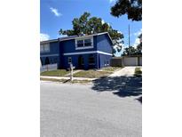 Charming two-story blue home with arched entryway, white trim, and well-maintained landscaping at 1947 Los Lomas Dr, Clearwater, FL 33763