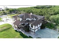 Stunning two-story home featuring a screened-in pool, lush landscaping, and a beautiful outdoor entertainment area near the waterfront at 2400 Miguel Bay Dr, Terra Ceia, FL 34250