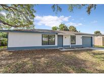 Charming single-story home featuring a white exterior, blue trim, and a well-maintained front yard at 400 E Baffin Dr, Venice, FL 34293