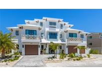 Stunning modern white townhouse with beautiful landscaping and a paver driveway at 401 39Th St, Holmes Beach, FL 34217