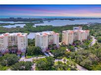 Stunning aerial view of three luxury condominiums with water views and lush landscaping at 401 N Point Rd # 504, Osprey, FL 34229