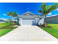 Charming single-story home showcasing a well-manicured lawn, complemented by palm trees and a two-car garage at 4210 Sea Marsh Pl, Parrish, FL 34219