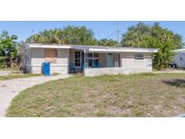 Exterior view of a single story house showing the covered porch with chairs and some damage at 5705 23Rd W St, Bradenton, FL 34207