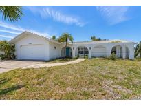 Charming single-story home with white exterior, arched entryway, and well-maintained front lawn at 6203 11Th W Ave, Bradenton, FL 34209