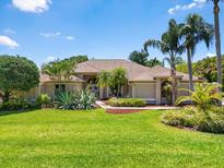Inviting front yard with lush green lawn and mature landscaping leading to the charming home at 7321 Hemlock Ln, Sarasota, FL 34241
