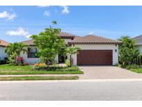 Charming one-story home with a tile roof, brick driveway, well manicured lawn, and attached two car garage at 8020 Clearwater Ct, Sarasota, FL 34241