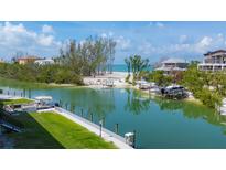 Beautiful waterfront property featuring a private dock, lush greenery, and serene views of the adjacent beach at 9200 Midnight Pass Rd # 30, Sarasota, FL 34242
