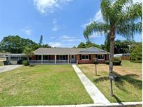 Charming single-story brick home featuring a covered front porch and lush green lawn on a sunny day at 2720 12Th Ave W, Bradenton, FL 34205