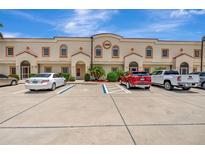 Beige two-story commercial building with parking lot on a sunny day at 1216 Rio De Janeiro Ave # 306, Punta Gorda, FL 33983