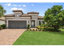 Charming single-story home featuring a tile roof, brick driveway, and a well-manicured front yard at 12856 Sorrento Way, Bradenton, FL 34211