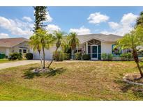 Charming single-story home with well-manicured lawn and tropical landscaping at 1304 Alton Rd, Port Charlotte, FL 33952