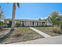 Charming single-story home featuring a well-manicured lawn, inviting walkway, and beautiful landscaping at 149 Small Se St, Port Charlotte, FL 33952