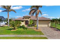 Beautiful home exterior showcasing lush landscaping, paver driveway, terracotta roof, and inviting curb appeal at 1736 Suzi St, Punta Gorda, FL 33950