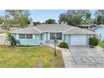 Lovely single-story home showcasing a tidy front yard, long driveway, and an attached garage at 1801 Forest Dr, Oldsmar, FL 34677