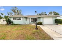 Charming single-story home with a well-maintained lawn, front garden, and attached one car garage at 1801 Forest Dr, Oldsmar, FL 34677