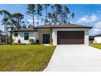 Charming single-story home featuring a manicured lawn, neutral paint scheme, and an attached two-car garage at 2638 Hagerick Ln, North Port, FL 34288