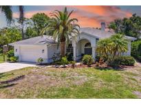 Charming single-story home with a two-car garage, lush landscaping, and a well-maintained front yard at 3988 Berlin Dr, Sarasota, FL 34233