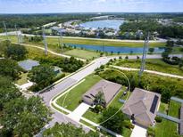 Stunning aerial view of single Gathering home in planned community near lake and green spaces on a sunny day at 4615 73Rd E St, Bradenton, FL 34203
