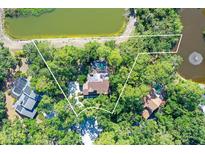 Stunning aerial view of the property featuring a pool, lush greenery, and waterfront on a large lot at 4917 Leatha Ln, Sarasota, FL 34232