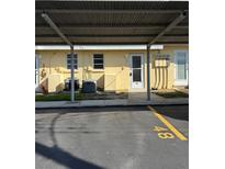 Exterior shot featuring covered parking and well-maintained landscaping at 6006 Midnight Pass Rd # 48, Sarasota, FL 34242