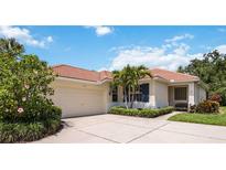 Charming single-story home boasts a red tile roof, manicured landscaping, and a two-car garage at 706 Misty Pond Ct, Bradenton, FL 34212