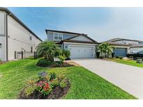 Charming two-story home with a well-manicured lawn, landscaping, and a two-car garage at 8940 Royal River Cir, Parrish, FL 34219