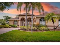 Charming single-story home with arched entryways, lush landscaping, and a well-manicured lawn at 11022 Pine Lilly Pl, Lakewood Ranch, FL 34202