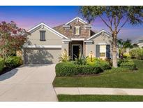 Charming home with stone accents, lush landscaping, and a well-manicured front lawn at 12908 Crystal Clear Pl, Bradenton, FL 34211