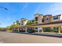 Multi-story condo with covered parking featuring stone accents and lush landscaping at 17118 Vardon Ter # 404, Bradenton, FL 34211