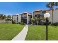 Inviting condo building with manicured lawn and charming walkway leading to the entrance at 3253 Beneva Rd # 103, Sarasota, FL 34232