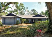 Charming one-story home featuring a well-manicured front yard, blue siding, and an attached two-car garage at 4137 Woodview Dr, Sarasota, FL 34232