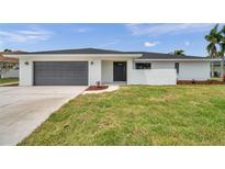 Charming single-story home featuring a gray garage door and a well-manicured lawn at 5125 Palm Aire Dr, Sarasota, FL 34243