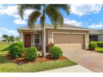 Charming single-story home with a well-manicured lawn, beautiful landscaping, and a brick-paved driveway at 5358 Shell Mound Cir, Punta Gorda, FL 33982