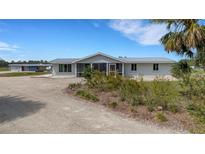 Lovely home featuring a metal roof, screened porch and mature landscaping at 7160 Myakka Valley Trl, Sarasota, FL 34241