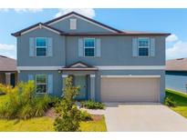 Two-story home with a blue exterior, light shutters, a two-car garage, and a well-manicured lawn at 8656 40Th E Cir, Palmetto, FL 34221